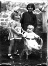Olivier près de sa sœur, assise dans un petit fauteuil en rotin [durant l'été 1932].
