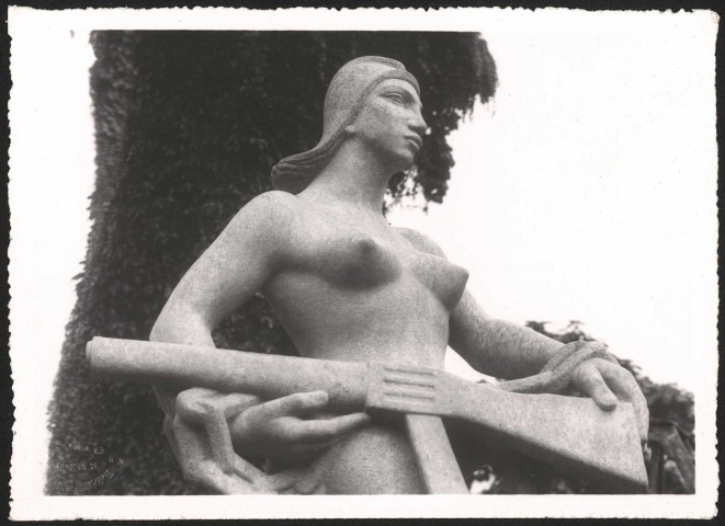 Statue en pierre d'une femme enchaînée et armée d'un fusil.
