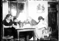 Camille, Jeanne et leur fille Lucienne, assis autour d'une table et lisant.