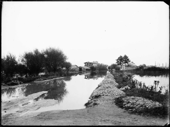 Canal de Jonage : vue de la route des Charpennes à Vaulx-en-Velin et de la tuilerie Janin lors de la crue du 3 novembre 1896.
