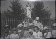 Devant la statue d'une Vierge à l'Enfant.