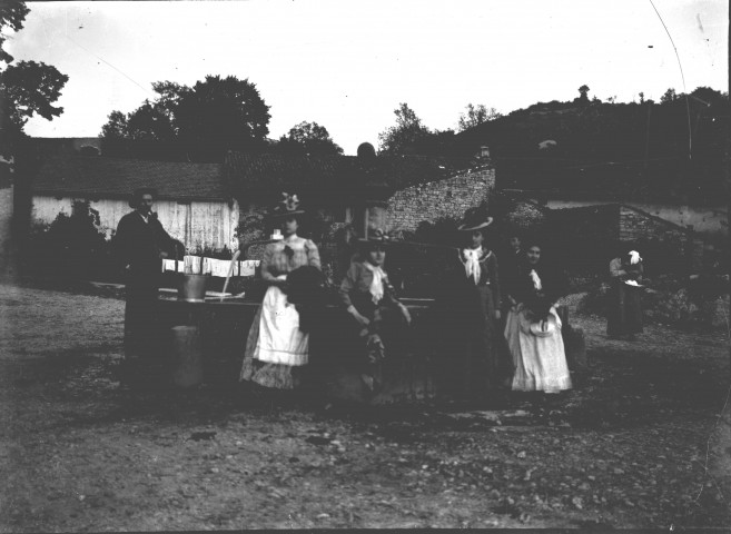 Groupe de femmes et d'hommes autour de la fontaine du village.