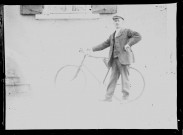 Homme debout tenant le guidon de son vélo.