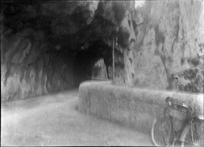 La route avec un vélo contre la rambarde de pierre.