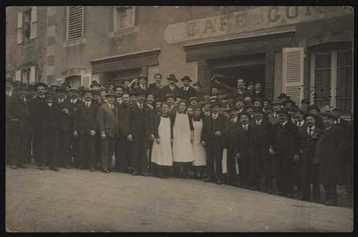 Femmes en tablier blancs encadrées d'une foule d'hommes en costumes et chapeaux.