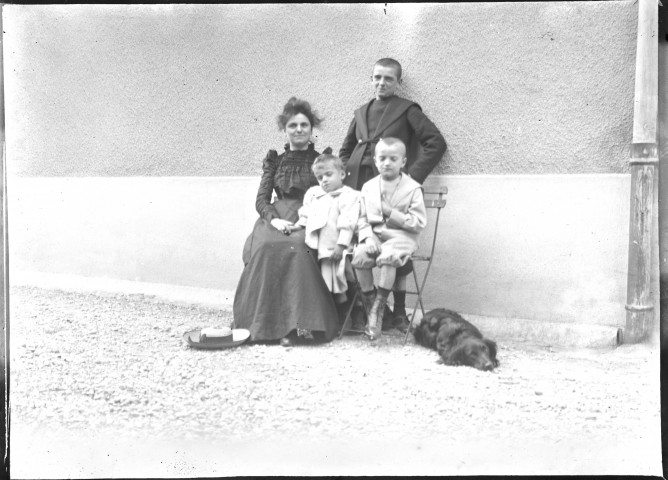 Mère avec ses trois fils et leur chien.